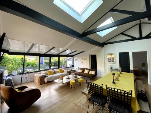 d'un salon avec un plafond et des lucarnes. dans l'établissement L echo des pins, plage à pied, à Merville-Franceville-Plage