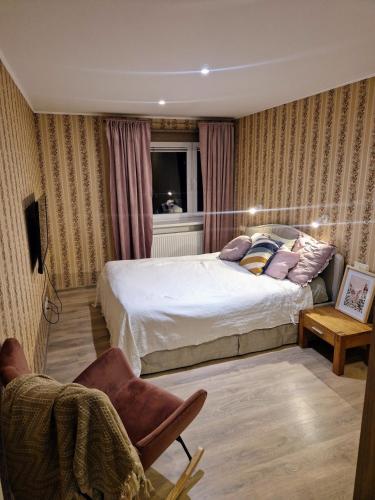 a bedroom with two beds and a chair at Cosy apartment in Padise in Padise