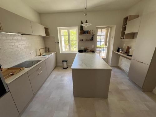 une cuisine avec des armoires blanches et un comptoir dans l'établissement Mas La Magnanerie du Ventoux, à Malaucène