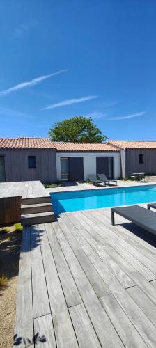 - une piscine avec deux bancs à côté d'un bâtiment dans l'établissement L'envie, à Saint-Gilles-Croix-de-Vie