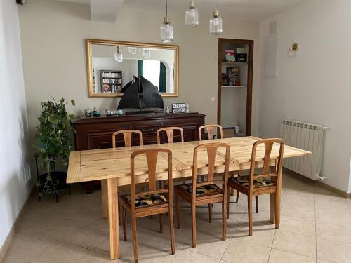 - une table à manger en bois avec des chaises et un miroir dans l'établissement Maison de village, à Labastide-dʼAnjou