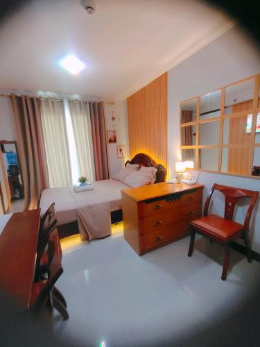 a bedroom with a bed and a desk and chairs at Adam&Eva Condo Staycation in Lapu Lapu City