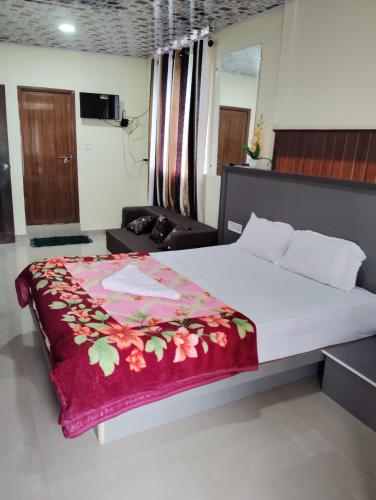 a bedroom with a bed with a red blanket on it at Riya Home Stay Munnar in Anaviratty