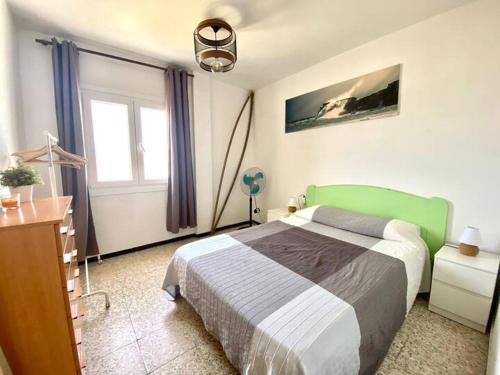 een slaapkamer met een groen bed en een raam bij Apartamento vista mar Tarifa in Tarifa