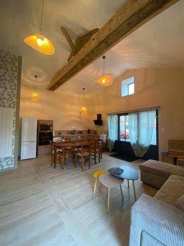 un salon avec une table et une salle à manger dans l'établissement La grange des Arondes, à Les Magnils-Reigniers
