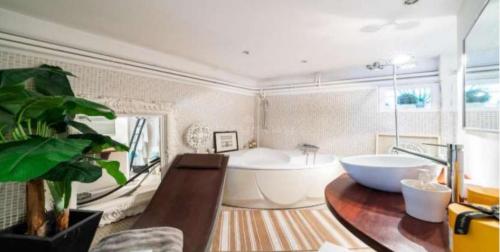 La salle de bains est pourvue d'une grande baignoire et d'un lavabo. dans l'établissement Centre cannes Galia 210 m2, à Cannes