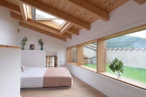 a bedroom with a bed and a large window at Casa Potenta in Llimiana