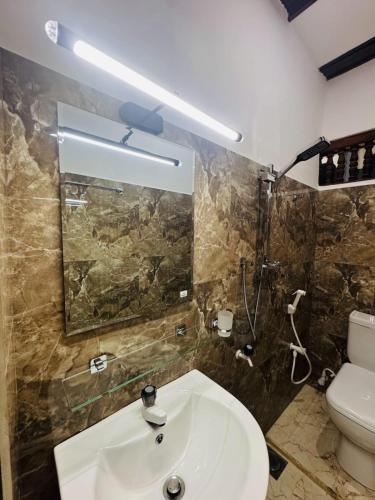 a bathroom with a sink and a toilet at Humming Birds Suites in Jaffna