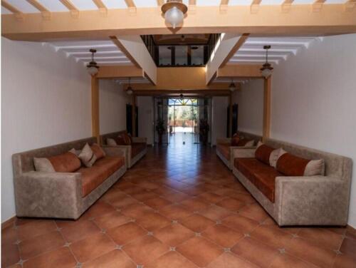 a large living room with couches and a ceiling at Hotel OUM EL FADL in Fkih Ben Salah