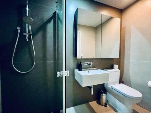 a bathroom with a shower and a toilet and a sink at Stylish High-Rise City Retreat in front of Southern Cross in Melbourne