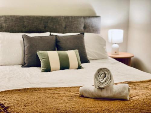 a bed with a rolled up towel on top of it at Stylish High-Rise City Retreat in front of Southern Cross in Melbourne