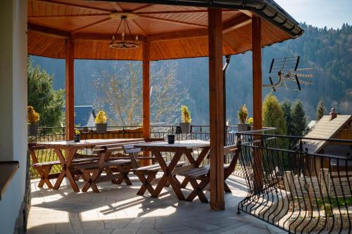 a wooden pavilion with a table and chairs on a deck at Kamila in Szczawnica