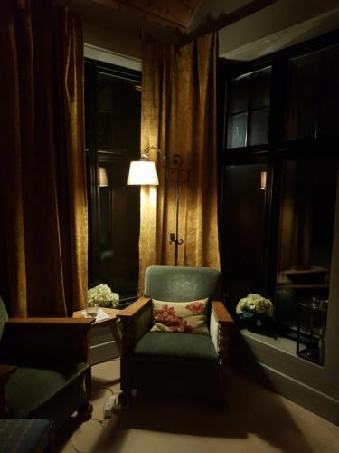 a living room with a chair and a table and a lamp at Villa Fjara sleeps 22 in 6 bedrooms in Ulven