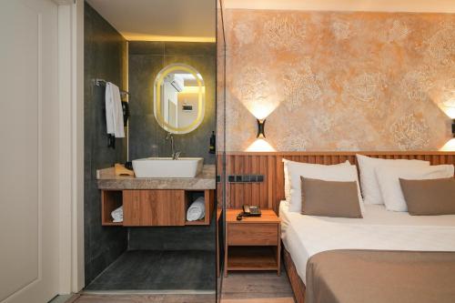 a hotel room with a bed and a sink at Der Inn Lara in Antalya