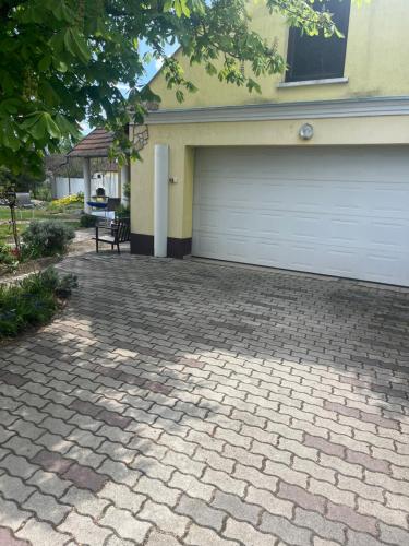 a house with a garage and a bench in front of it at Vidéki Vendégház in Doboz