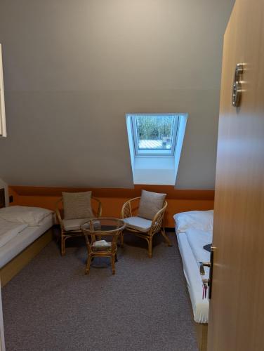a room with two beds and a table and chairs at Pension Harcovna in Frýdlant nad Ostravicí