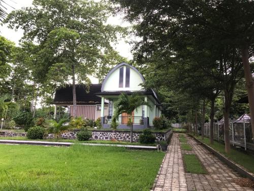 a white house with a dome on top of a yard at Pohon Purba Resort & Restaurant in Labuan Lombok