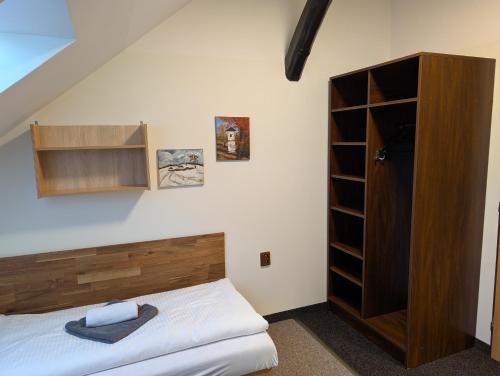 a bedroom with a bed and a wooden cabinet at Pension Harcovna in Frýdlant nad Ostravicí