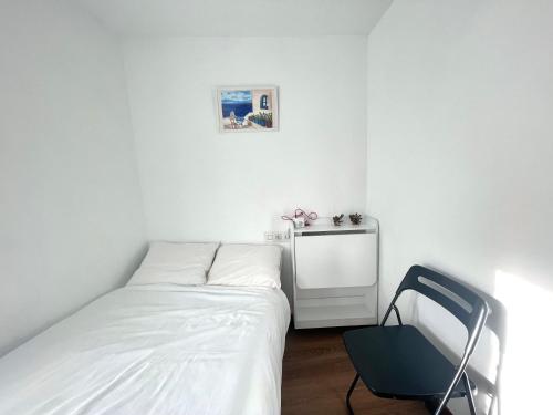a bedroom with two beds and a chair in it at La Atalaya in Laredo