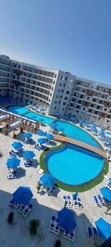 an aerial view of a hotel with blue umbrellas and swimming pools at Zahabia Golden Beach Resort Down Town in Hurghada