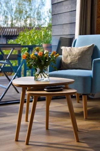 a coffee table with a vase of flowers on a patio at Mimosa bed & breakfast in IJsselmuiden in IJsselmuiden
