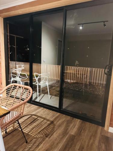 a screened porch with chairs and tables on a balcony at Natural & Relax House in West Ulverstone in Ulverstone