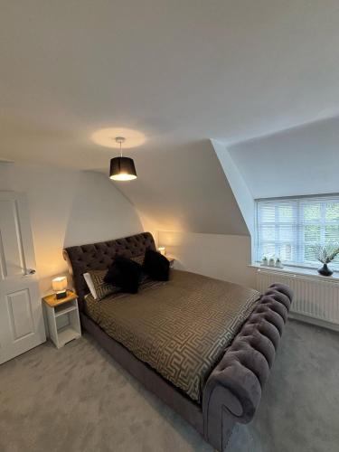 a bedroom with a large bed in a room with a window at Lupin Cottage Hot Tub Hide Out Dog Friendly in Weymouth