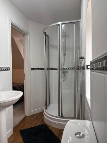a bathroom with a shower and a sink at Lupin Cottage Hot Tub Hide Out Dog Friendly in Weymouth