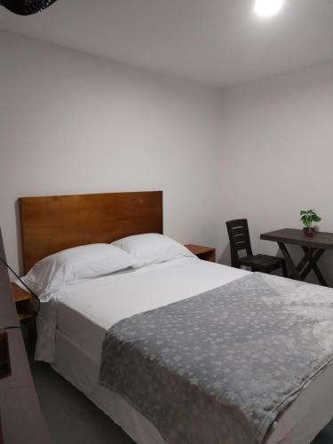 a bedroom with a bed and a table and a chair at Las Cascadas Hostel in Buritaca