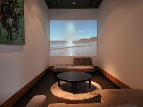 a room with a table and a couch and a window at KAMAKURA Beach House in Kamakura