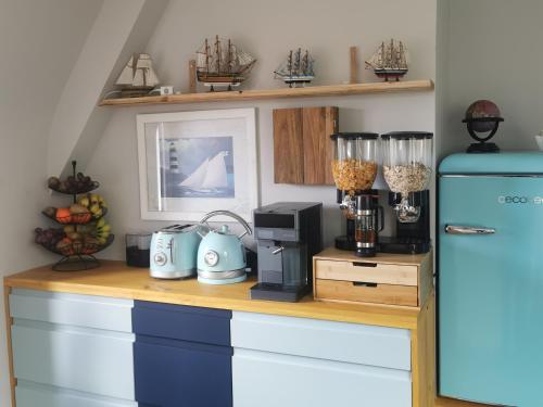 a kitchen with a counter with a blue refrigerator at Les pieds dans l'eau in Saint Malo