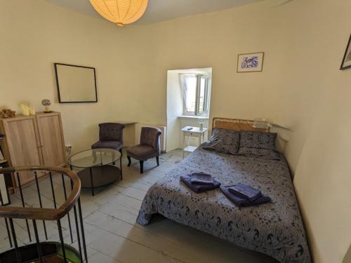 une chambre avec un lit, une table et des chaises dans l'établissement La tour médiévale du Château de la Carrée, à Saint-Germain-en-Coglès