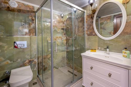 een badkamer met een douche, een toilet en een wastafel bij White Garden Villas Studio Patara in Kas