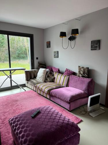 a living room with a purple couch and a table at Chambres Deluxe dans Villa Les Hauts d'Orfeuille à Beaumont les Valence & Monteleger in Beaumont-lès-Valence