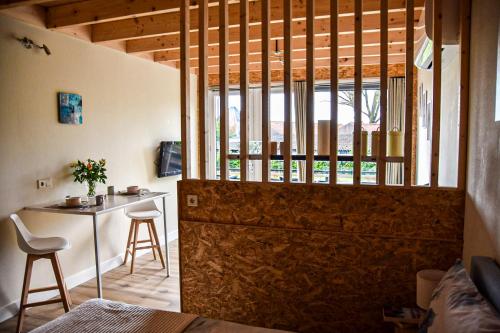 a room with a door and a table with chairs at Mimosa bed & breakfast in IJsselmuiden in IJsselmuiden