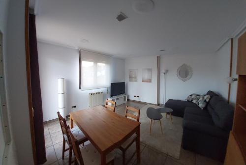 a living room with a couch and a table at Ático Jovellanos in Gijón