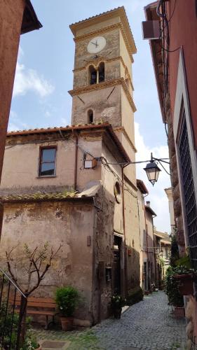 an old building with a clock tower on a street at L'Arco nel Borgo in Sacrofano
