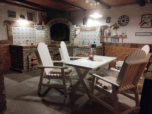 a table and chairs in a room with a fireplace at Kuća za odmor u Banatu in Debeljača