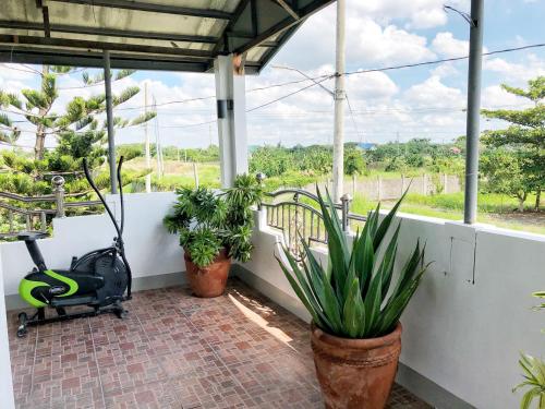 a porch with two potted plants and a treadmill at Roof Deck Suite at Matildes Sanctuary in Dampol