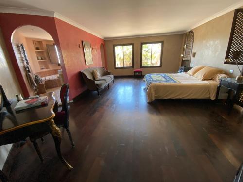 une chambre avec un lit, une chaise et une table dans l'établissement Chambre Ebene, Riad 9 Couple only au village naturiste, au Cap d'Agde