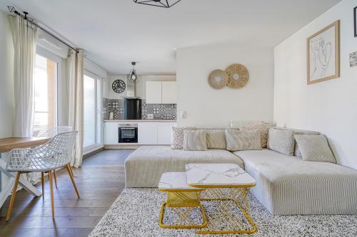 un salon blanc avec un canapé et une table dans l'établissement Sublime apartment proche Paris, à Argenteuil