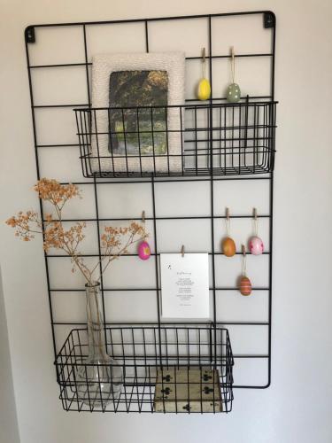a wire rack with a vase and ornaments on it at De Bakkerij in Deurningen