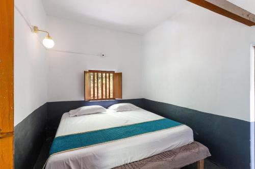 a small bed in a room with a window at Underground Hostel By Bilwa Estate in Madikeri