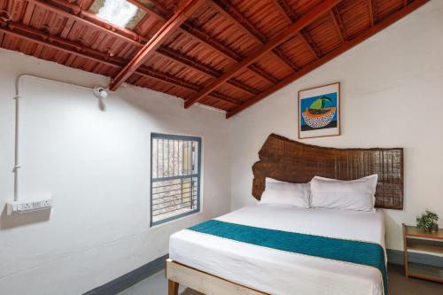 a bedroom with a bed and a window at Underground Hostel By Bilwa Estate in Madikeri