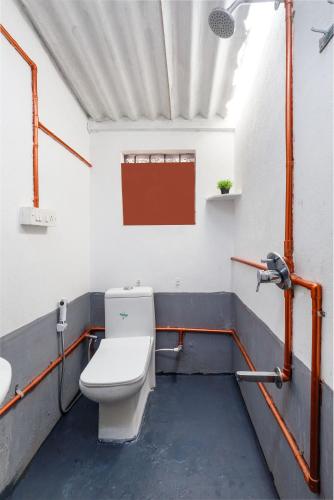 a bathroom with a toilet and a sink at Underground Hostel By Bilwa Estate in Madikeri