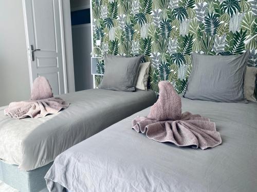 two beds with towels on top of them in a room at À La Mollière in Cayeux-sur-Mer