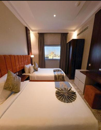 a hotel room with two beds and a couch at الافق سويت للشقق الفندقية in Hail