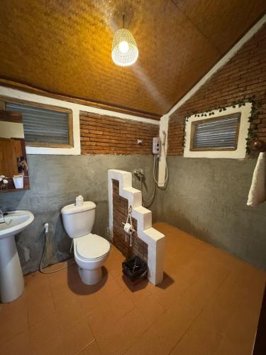 a bathroom with a toilet and a sink and a staircase at The Nest, Pai Love Resort in Thung Yao