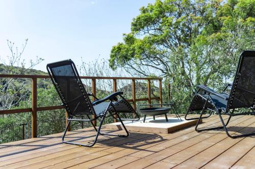 a couple of chairs sitting on top of a deck at amarancia cottage hugging nature house in Minamiawaji