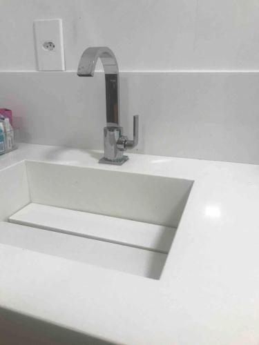 a white sink with a faucet on a counter at Vila dos ventos in Marataizes